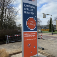 Grote reclamezuil 'Kandinsky College Nijmegen' geplaatst bij de schoolingang